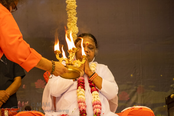 Swamiji waves light in front of Amma